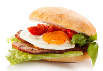 Breakfast - breadroll, fried egg, bacon and vegetables