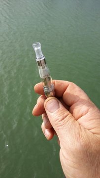 Main d'ouvrier et cigarette &eacute;lectronique