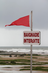 Drapeau rouge et panneau baignade interdite