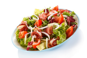Vegetable salad with ham on white background
