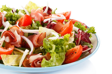 Vegetable salad with ham on white background