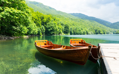 Wooden boats at pier on mountain lake