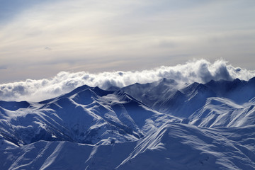 Fototapeta premium Snowy mountains in mist at winter evening