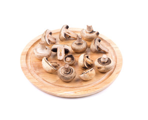 White mushrooms on wooden board.