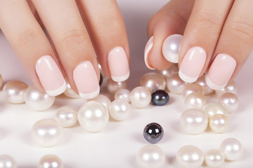 Obraz na płótnie Canvas Beautiful woman's nails with french manicure and pearls.