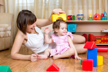 mom and child daughter play block toys home
