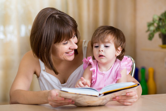 mother and kid daughter read a book