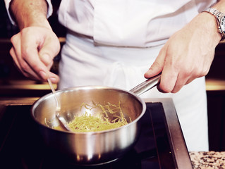 Chef is preparing dish with noodles