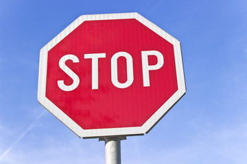 Stop road traffic sign over blue sky