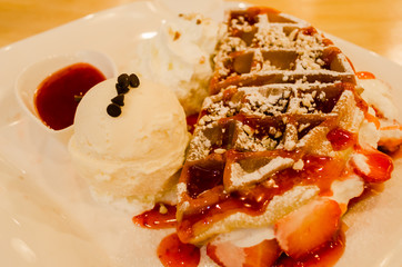 ice-cream with  Waffle topped by strawberry and jam