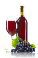 Glass of red wine with bottle and ripe grapes isolated