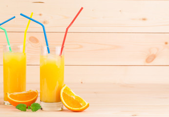 Orange juice and slices on wooden background.