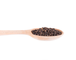 Black peppercorns on a wooden spoon.
