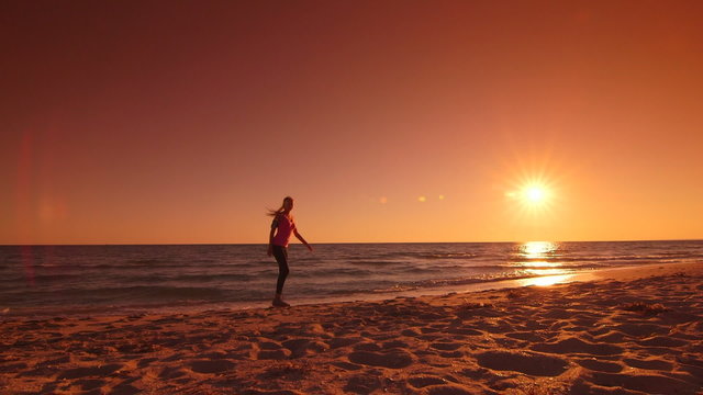 Fitness sporty woman jogging along the beach at sunset