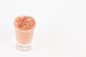 chili paste in glass on white paper background