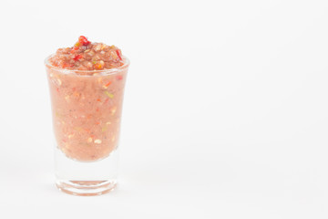 chili paste in glass on white paper background