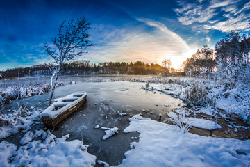 First snow in winter on the lake at sunrise