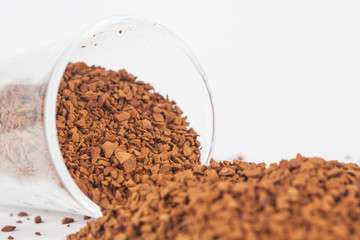 Instant coffee powder in glass with white paper background