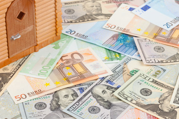 Plastic house on a pile of money