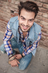 Fototapeta premium young man sitting on the side walk