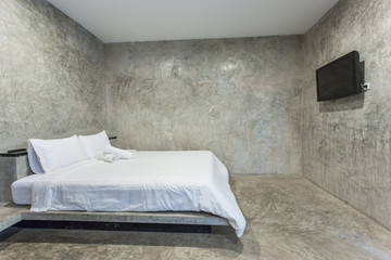 white bed with gray cement wall