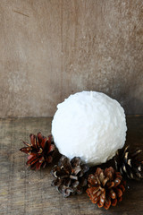 round candle and pine cones