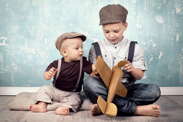 zwei Brüder spielen mit Holzflieger