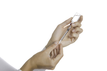 hands filling a syringe with an insulin vial