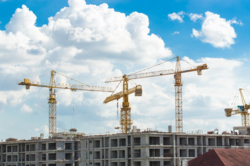 Construction site with cranes and blue sky background