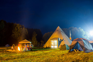 Tents in the tourist camp in a forest glade. Night.