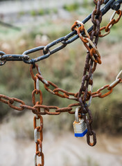 barrier formed by set of old chains with padlock