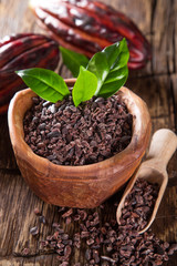 Cocoa pod with bowl on a dark wooden table.