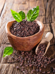 Cocoa pod with bowl on a dark wooden table.