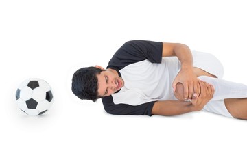 Soccer player lying down and shouting in pain