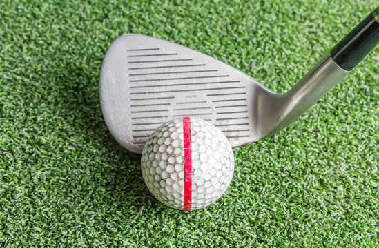 Close up, Old golf balls and iron on artificial grass.