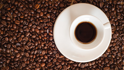 Cup of black coffee in the background grinder on a wooden rustic