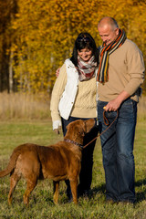 Couple with dog in sunny autumn park