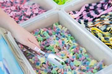 young woman takes jelly candies over the counter