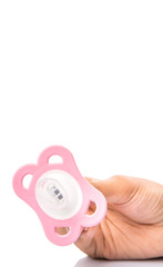 Female hand holding pink pacifier over white background