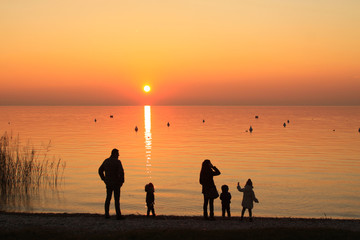 Famiglia al tramonto sul lago