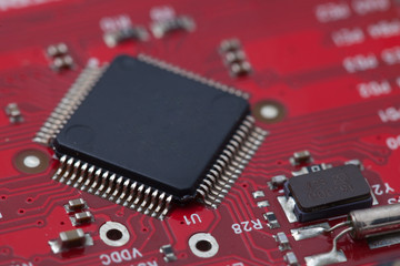 Black IC on red PCB