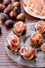 Fichi con roselline di culatello sul piatto