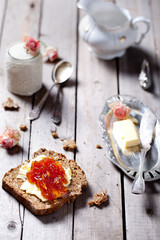 Piece of bread with butter, jam and  yogurt