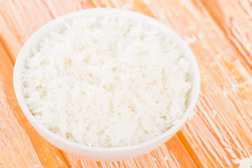 Steamed Rice - Boiled rice in a bowl on an orange background.
