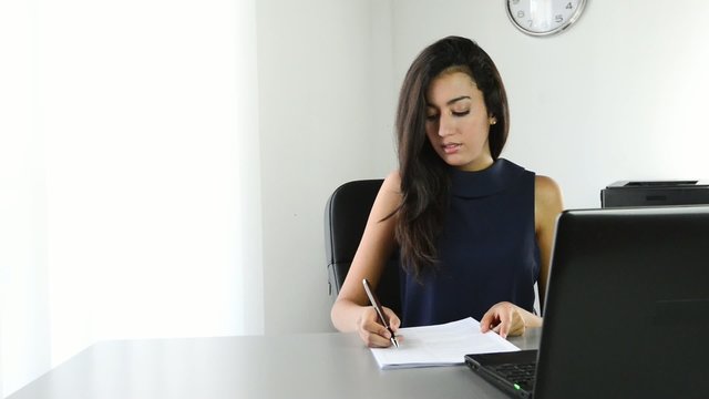 cheerful young business woman signing a contract