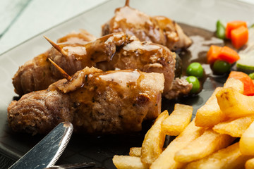 Pork rolls with french fries with vegetable