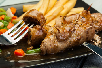 Pork rolls with french fries with vegetable