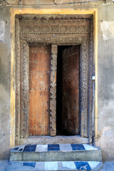 Fototapeta na wymiar Hand crafted wooden door in Stonetown at Zanzibar