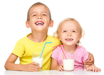 Cute little girl and boy are drinking milk