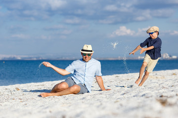 Happy father and his son having fun at the beach
